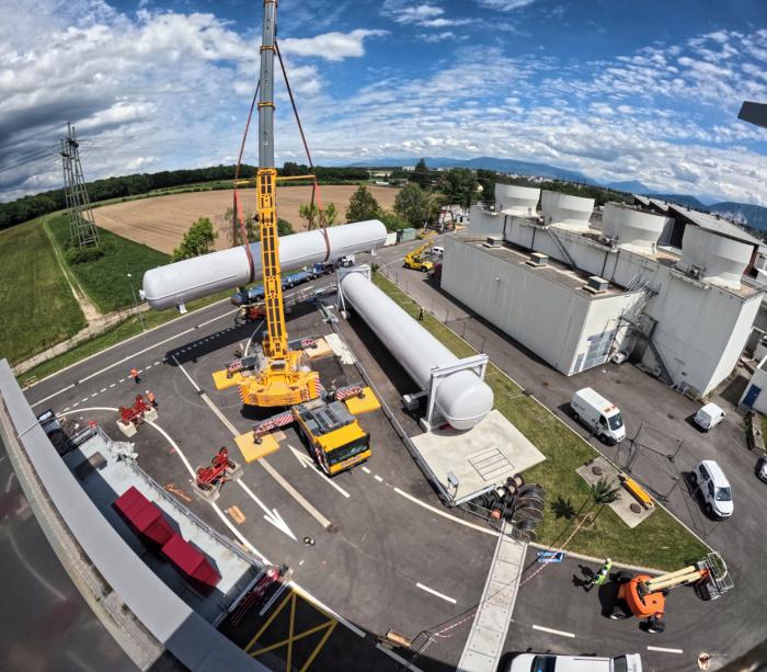 view from above of large cylindrical tank being carried by a crane