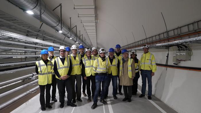 group of people in helmets and high-visibility vests in a tunnel